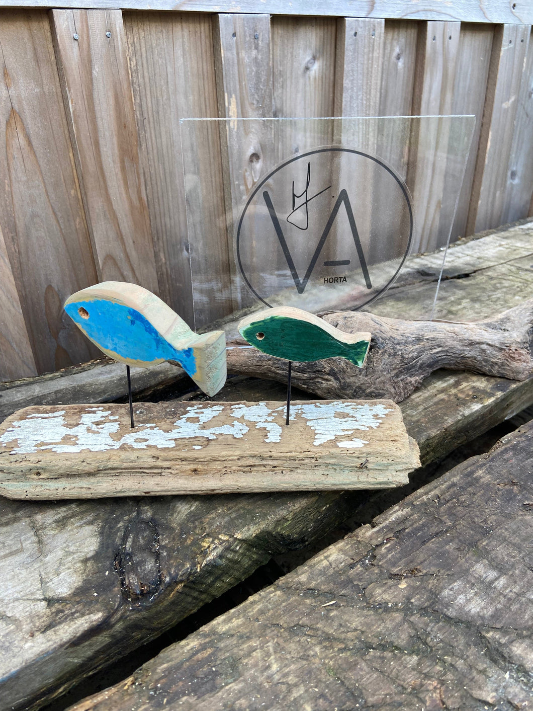 2 SMALL FISH ON A DRIFTWOOD OF A FISHING BOAT